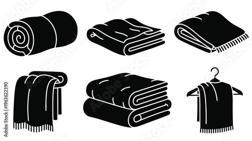 Folded towels and rolled blankets presented in a dark silhouette