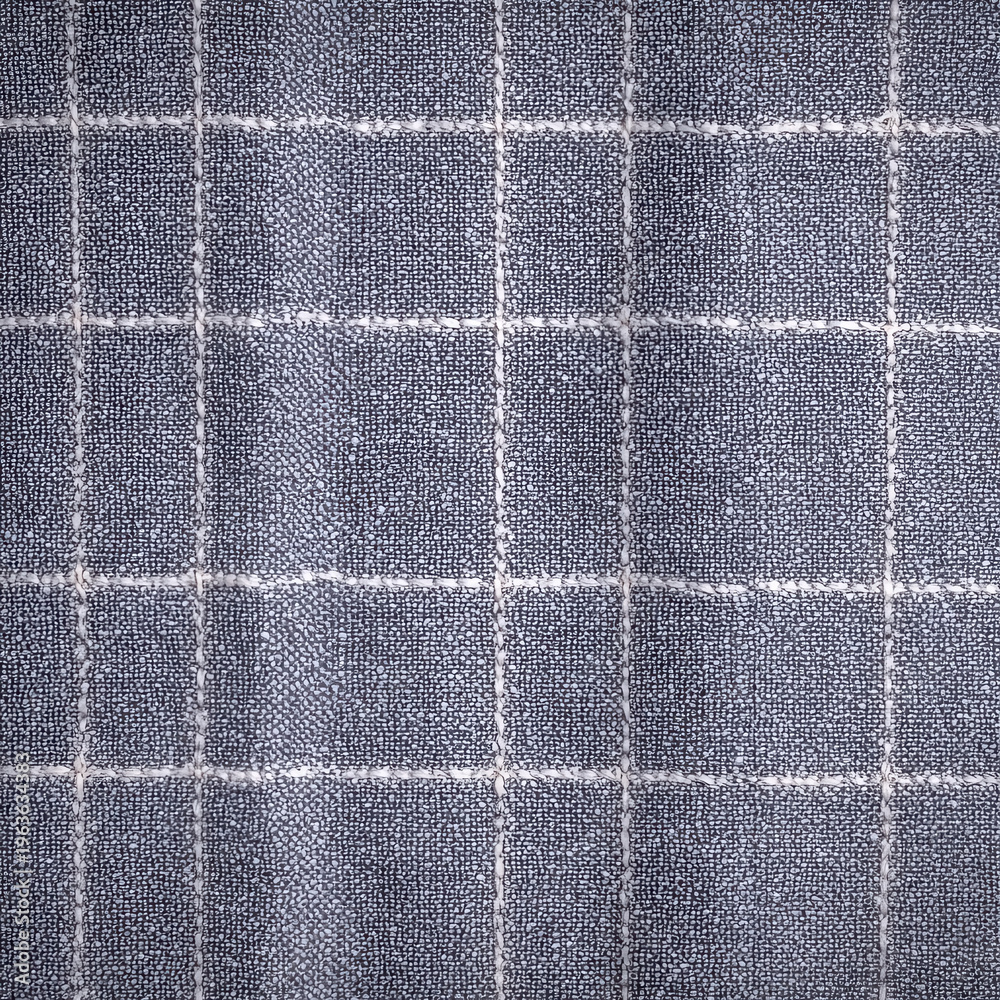 Fototapeta premium Fabric with grid pattern in blue and white on display at a textile market during afternoon hours