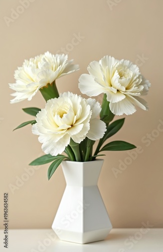 Three white carnations in a modern white vase against a neutral beige background. The floral arrangement is perfect for greeting cards, invitations, or spring decor.