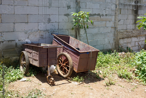 Konstfotografi Two rusty-brown old iron carts were parked in front of a cinder-block wall