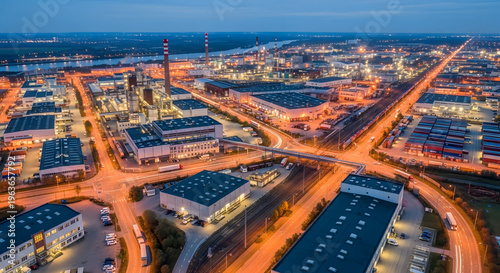 An aerial view showcases a sprawling industrial complex at dusk illuminated by city lights high quality