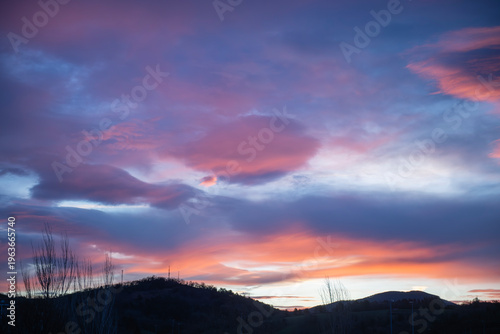 Fotografie Colorful sunset sky with dramatic clouds over mountain horizon