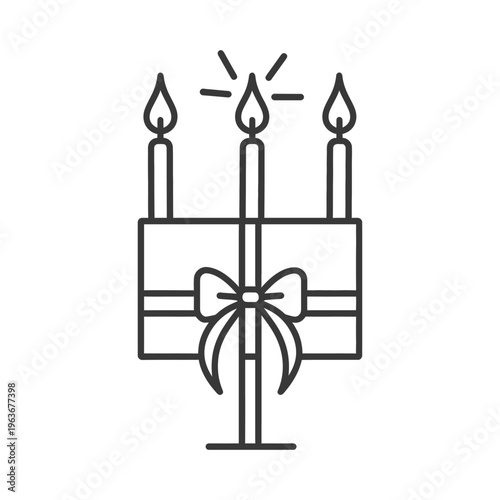 Three lit candles and a bow decorate a candle holder