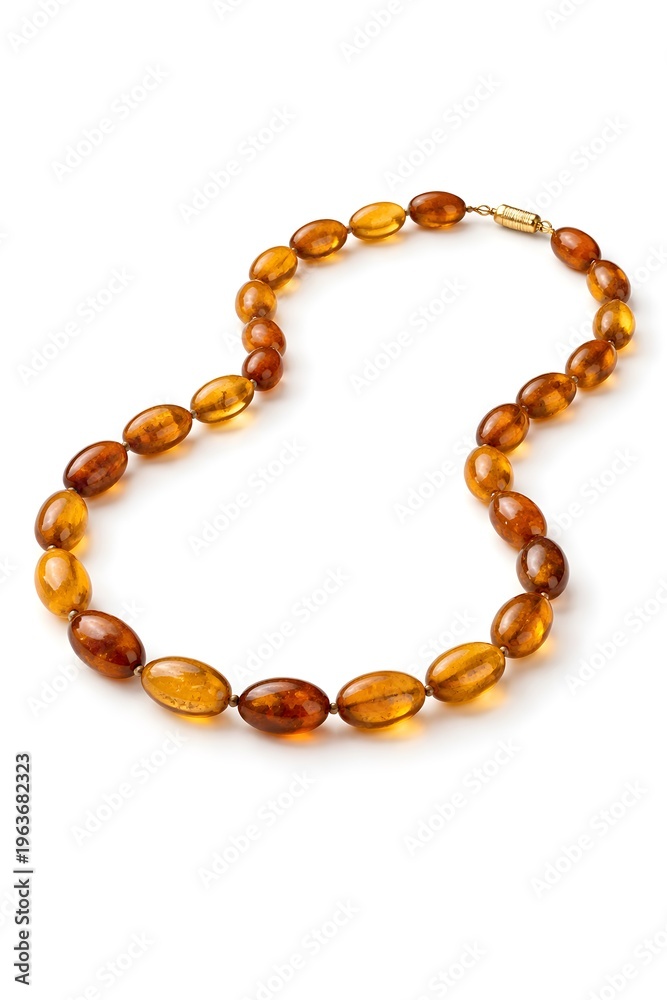 Obraz premium A necklace made of amber beads is placed on a white surface. The necklace shows various shades of amber, highlighting its design and craftsmanship