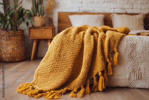 A soft yellow blanket is gracefully draped over the edge of a charming bed, set in a cozy room adorned with wooden decor and lush green plants, all illuminated by the warm rays of a sunny day