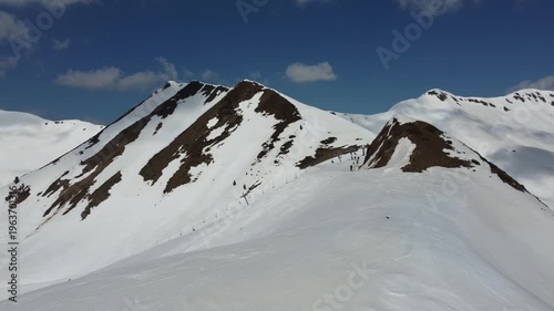 aerial view of skiers skiing in high snowy peak in the pyrenees