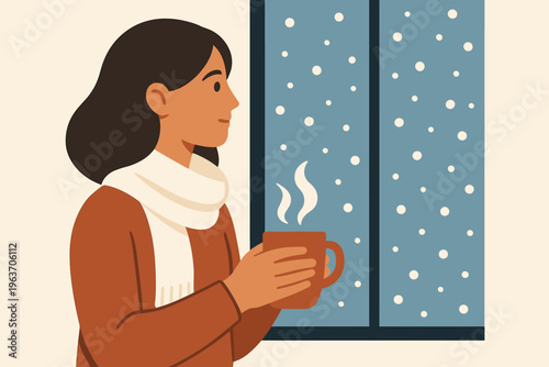 Woman enjoying a warm drink while watching snowfall through the window