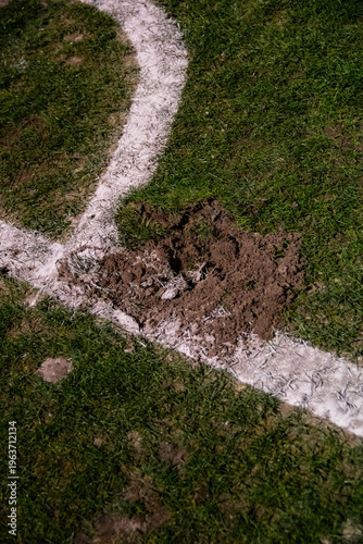 Billede på lærred Damaged football pitch with a deep divot next to a white touchline