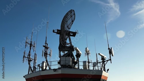 Large radar dish and antennas on ship under blue sky