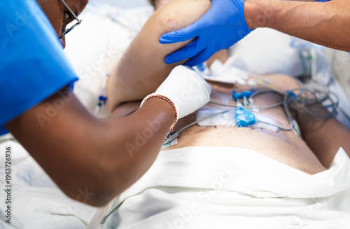 Medical team providing intensive care to patient with monitoring equipment