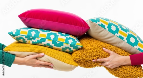 Two women holding a large stack of bright colorful pillows isolated on a white background.