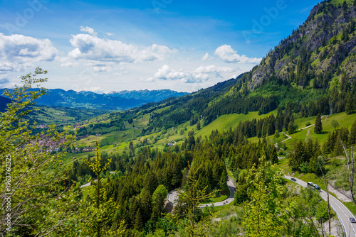 Foto Kurvenreiche Passstraße am Oberjochpass mit weitem Blick über die alpine Berglan