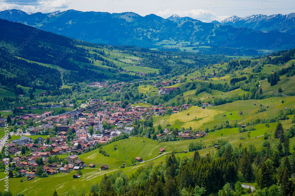 Fototapeta premium Panoramaansicht von Bad Hindelang im Allgäu mit grüner Landschaft und alpiner Bergkulisse im Sommer
