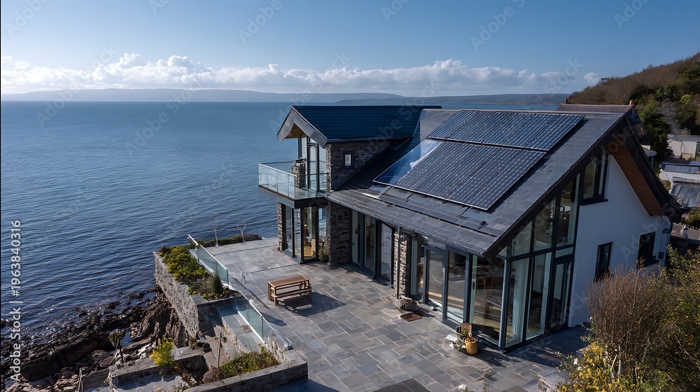 Fototapeta premium Modern Luxury Coastal Villa with Solar Panels, Panoramic Sea Views, Stone Terrace, and Glass Balconies, Sunny Day