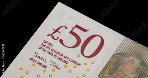 A fragment of a 50 British pound note on a black background