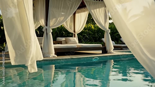 Empty poolside cabana with white curtains in tropical setting