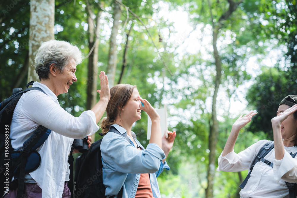Obraz premium Camp party outdoor holiday relax with friends in forest, joyful group high five together, enjoying nature, adventure, happiness, bonding, and fresh air in green woodland setting