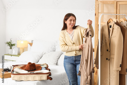 Young woman with coat packi...
