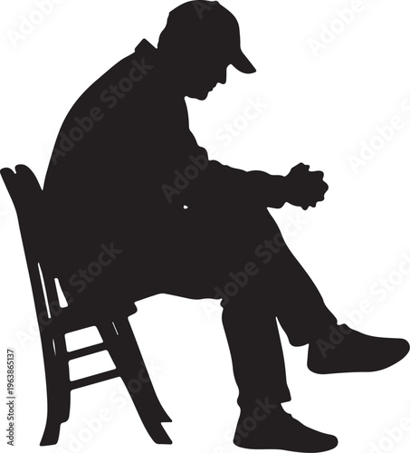 Silhouette of a sad contemplative man in a cap sitting on a chair