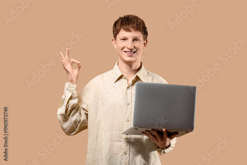Young man with laptop showi...