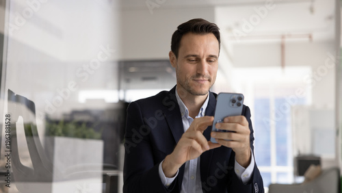 Billede på lærred Confident Hispanic business professional executive using mobile phone at office