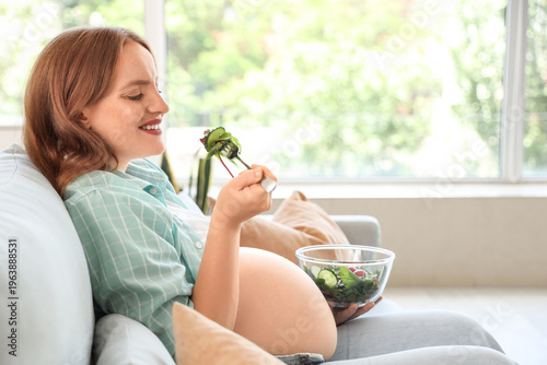 Young pregnant woman eating...