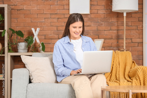 Smiling young woman using l...