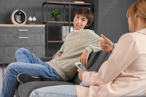 Teenage boy talking to psychologist in office