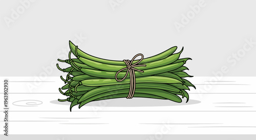 A bundle of vibrant green beans tied with twine rests on a wooden surface