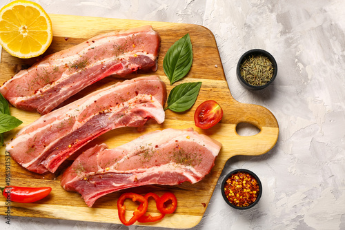 Wooden board with raw pork ...