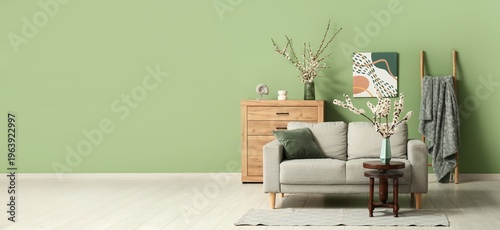 Interior of room with sofa and blooming branches. Banner for design