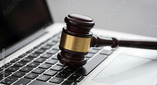 Close up gavel resting on laptop keyboard symbolizing legal technology and digital justice