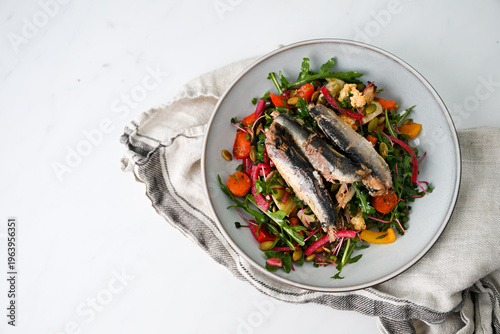 Plate with Vegetables and Greens Salad with Canned Sardines on It