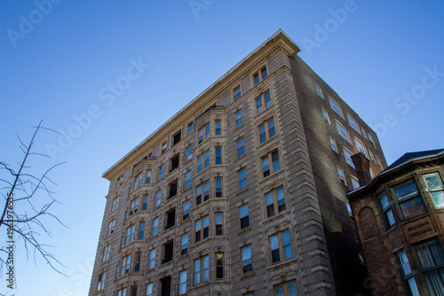 random residential apartment building in urban area, looks old-timey, brick masonry  with windows and street views