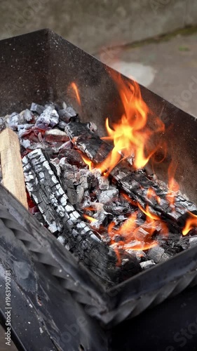 Fire flames in barbecue grill outdoors activities leisure in backyard. Concept of summer holidays party Slow motion Preparing burning woods for bbq cooking food Summertime