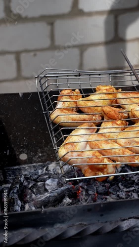 Delicious chicken frying on barbecue grill grate outdoor. Seasoning falling on fresh grilled chicken wings. Summer party food ideas. BBQ Juicy roasting chicken grill legs on grill grate 