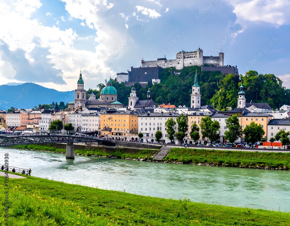 Fototapeta premium Cityscape view castle on hill, river in foreground, colorful buildings