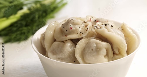 Freshly cooked hot dumplings sprinkled with a mix of black and red pepper.