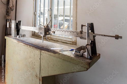 Detailed view of old industrial weighbridge scale showing numbered beam and sliding counterweight