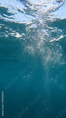 Peaceful Underwater View of Ascending Air Bubbles Rising to Surface in Clear Deep Blue Ocean Water with Natural Sunlight Rays Vertical Cinematic Nature Footage