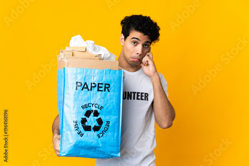 Young Venezuelan man holding a recycling bag full of paper to recycle thinking an idea