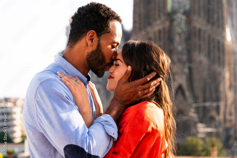 Obraz premium Multiracial beautiful happy couple of lovers dating in Barcelona on a rooftop with amazing city view