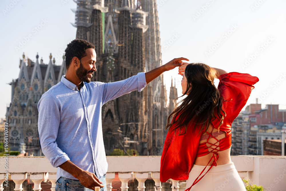 Obraz premium Multiracial beautiful happy couple of lovers dating in Barcelona on a rooftop with amazing city view