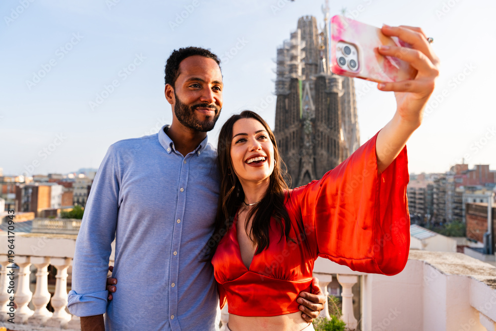 Naklejka premium Multiracial beautiful happy couple of lovers dating in Barcelona on a rooftop with amazing city view