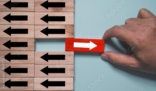 Canvas Print Leadership and innovation concept with hand placing red arrow block opposite dir