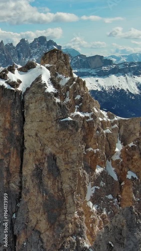 Aerial around view of majestic rocky mountains in snow Alps, Dolomites, Italy. Vertical video 4k