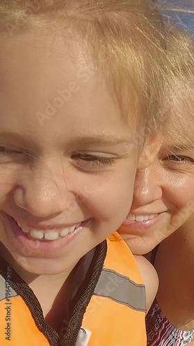 Happy family look at camera and smile riding sup on blue summer sea. Father mother and daughter on paddleboard. Sup board. Travel vacation holiday. Vertical shot