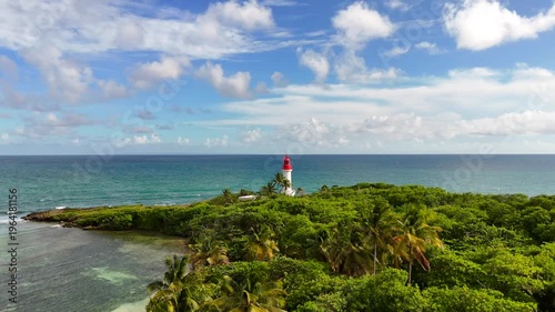 Aerial drone footage of Ilet du Gosier island near Pointe-à-Pitre, Guadeloupe. Scenic tropical landscape with white sandy beach, turquoise Caribbean Sea and iconic lighthouse. Popular travel destinati