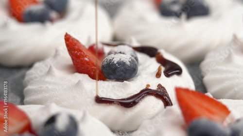 Close up of chocolate is poured on vanilla meringue with powdered sugar and berries. Dessert. Bakery