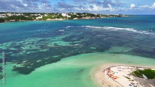 Aerial drone footage of Ilet du Gosier island near Pointe-à-Pitre, Guadeloupe. Scenic tropical landscape with white sandy beach, turquoise Caribbean Sea and iconic lighthouse. Popular travel destinati